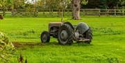 Vintage tractor in a green field, by James Crisp