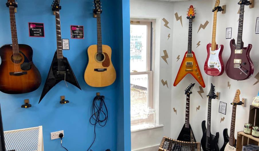 Display of acoustic and electric guitars on the wall