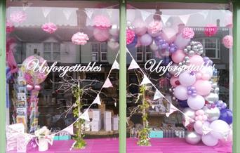 window of Unforgettables with balloons and bunting