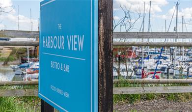Blue sign for Harbour View in front of the marina