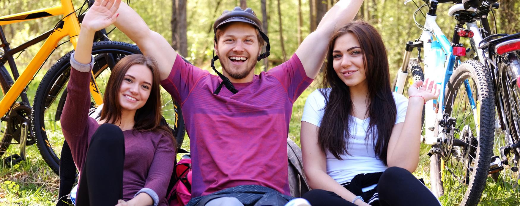 three friends with bikes in park