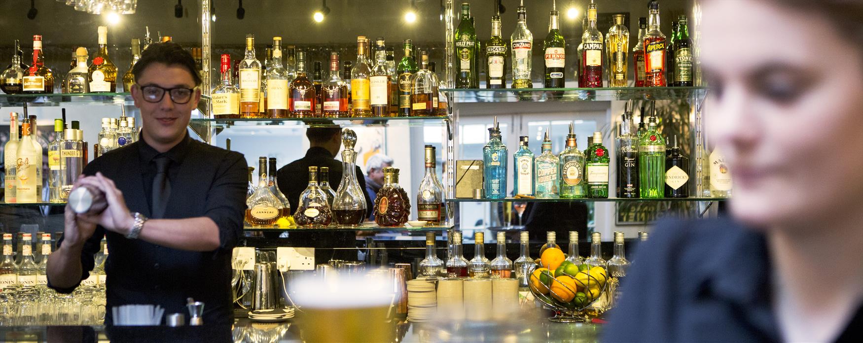 Person making cocktails at a bar