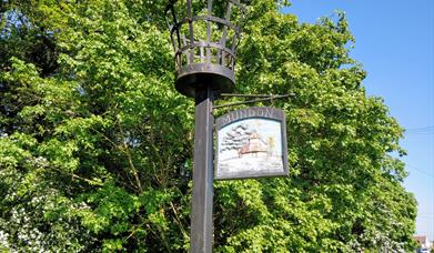 Mundon Village Sign with the beacon above it