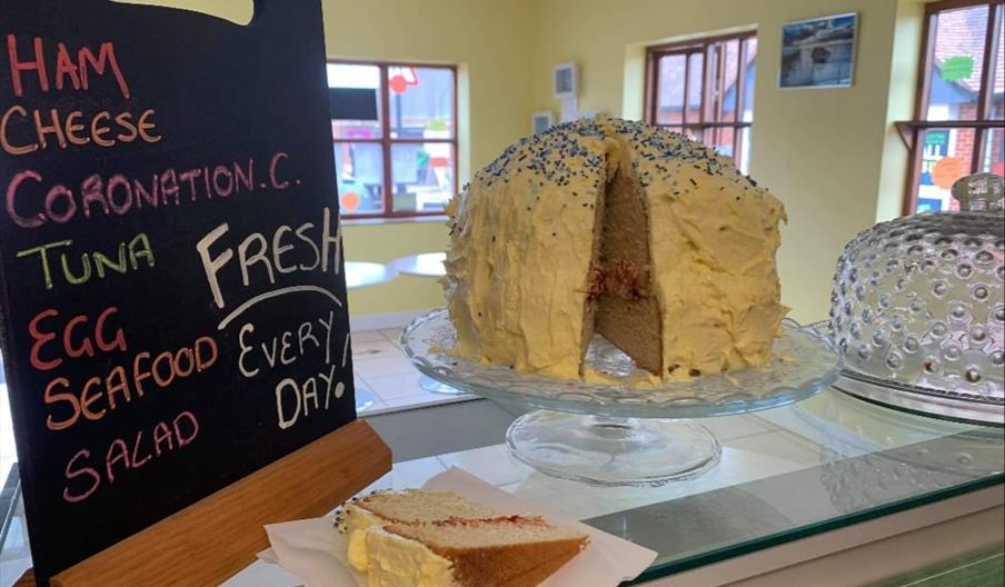 Huge, beautifully decorated home made cake on counter of Crouch cafe