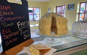 Huge, beautifully decorated home made cake on counter of Crouch cafe