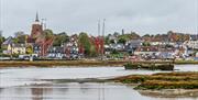 Beautiful views back to Maldon from Heybridge Basin with the tower of St Mary's church and red Thames Sailing Barge sails