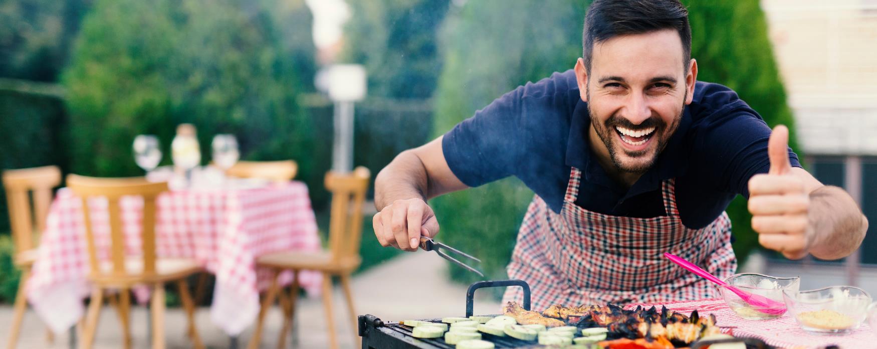 Man cooking barbecue gives a thumbs up