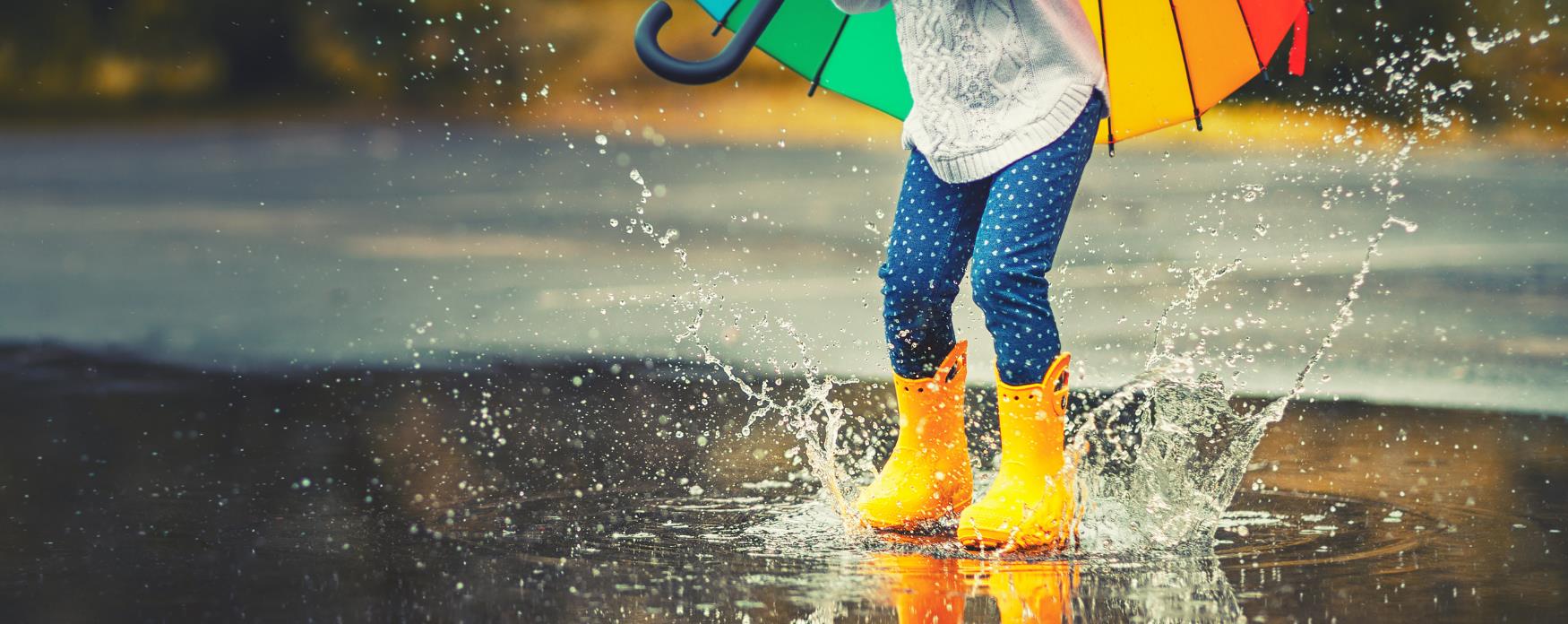 A child jumping in puddles of water