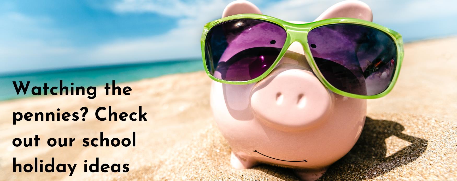 Piggy bank with sunglasses on by the beach