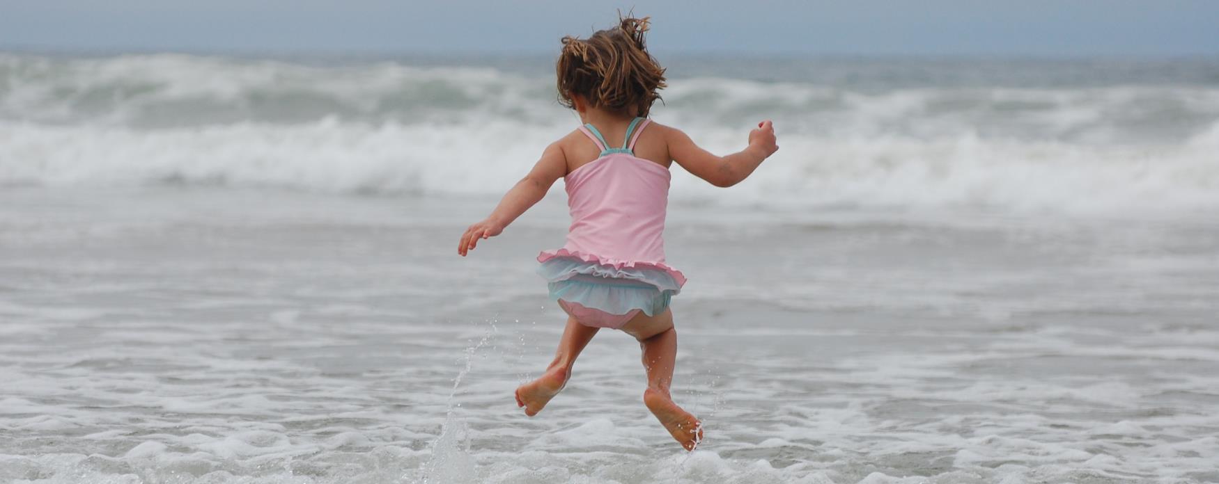 Child jumping in the waves at the seaside