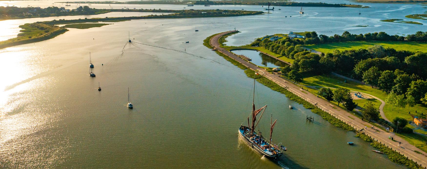 Aerial view of a thames barge sailing alongside Promenade Park