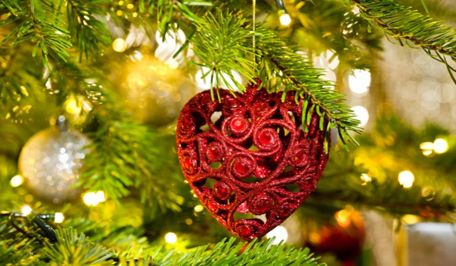 Real Christmas tree with heart-shaped bauble