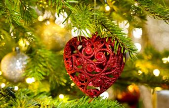 Real Christmas tree with heart-shaped bauble