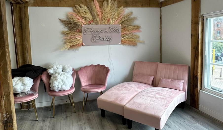Room at Pamper me Pretty with dusky pink chairs and couches
