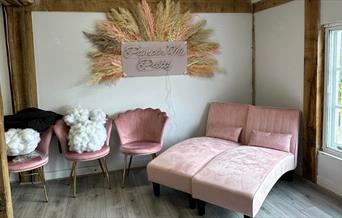 Room at Pamper me Pretty with dusky pink chairs and couches