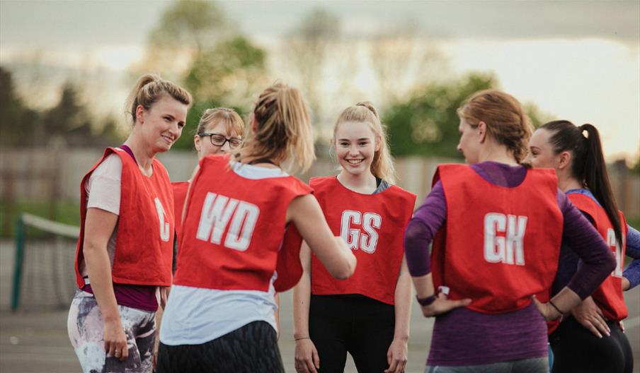 A group of women playing netball outdoors