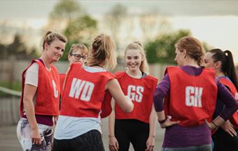 A group of women playing netball outdoors