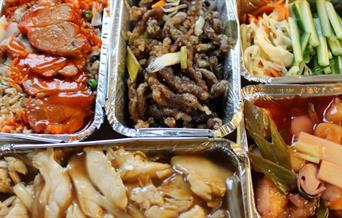 Array of takeaway Chinese food in foil containers