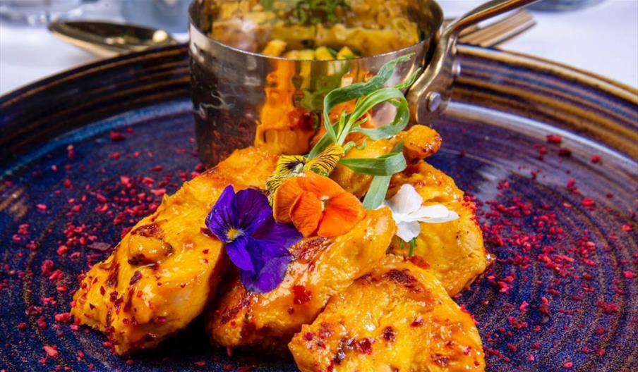 Delicious plate of Indian food topped with edible flowers