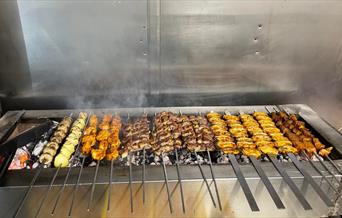 Delicious looking selection of Turkish kebabs cooking over a charcoal grill