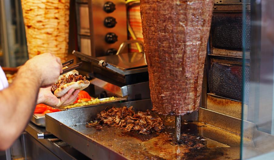 Man slicing meat from a doner kebab