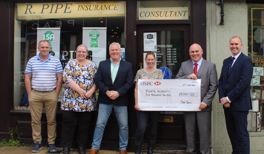 Cheque being presented to Plume School by Roy Pipe Insurance