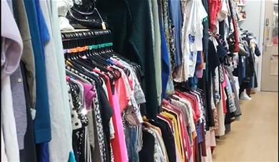 Rails of colourful ladies' clothes at the Salvation Army charity chop