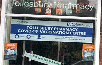 Window of Tollesbury Pharmacy advertising vaccinations