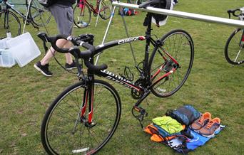 Triathlon bike and pile of clothes ready for racing transition