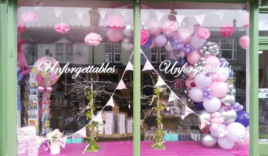 window of Unforgettables with balloons and bunting