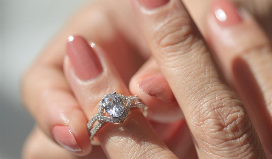 woman putting diamond ring on to her finger