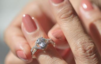woman putting diamond ring on to her finger