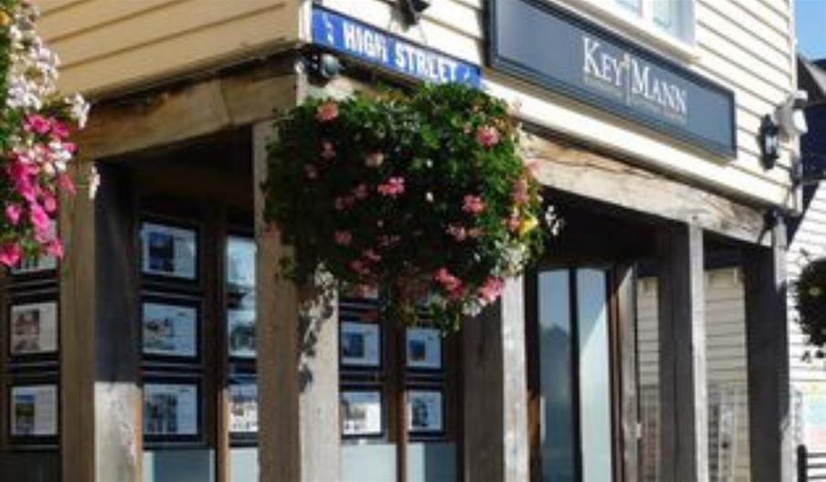 Outside of KeyMann with wooden beams and hanging baskets of flowers