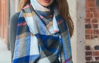 Woman modelling plaid scarf from Lewis Fashion