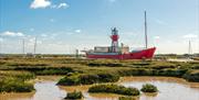 Bright red Trinity lightvessel moored in the saltmarshes