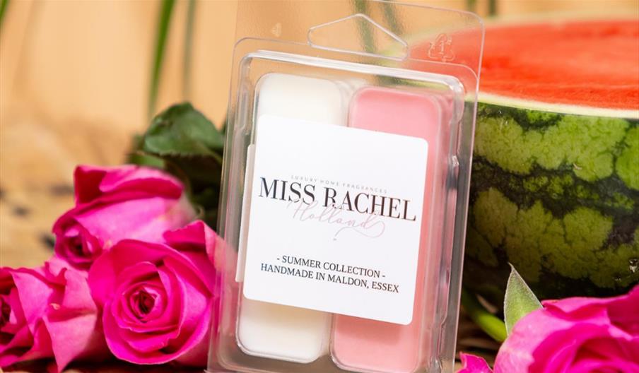 Scented wax melts made in Maldon by Miss Rachel Holland, alongside roses and a watermelon