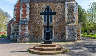 Wooden cross of Tollesbury war memorial in front of church