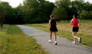 A pair of runners running through a park
