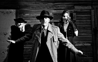 A group of actors in crime noir themed costumes.