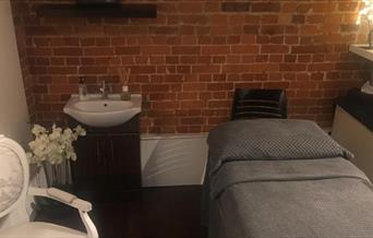 The Spa Maldon comfortable treatment room with couch, flowers and chair