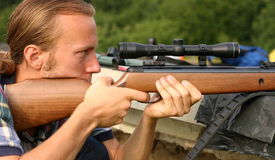 A man aiming down the sights of an air rifle